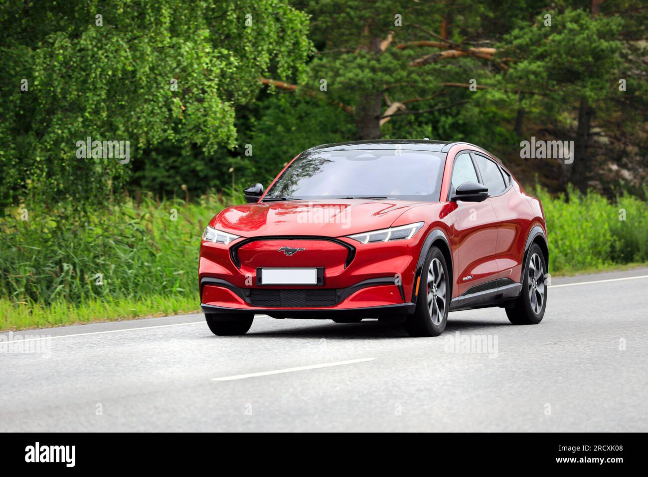 SUV crossover compatto elettrico Ford Mustang Mach-e a batteria rossa ad alta velocità su strada in un giorno d'estate. Salo, Finlandia. 6 luglio 2023. Foto Stock