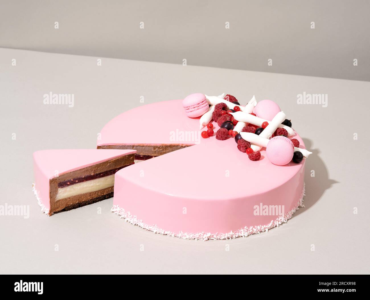Un primo piano di una deliziosa torta con un condimento al lampone e al cioccolato bianco Foto Stock