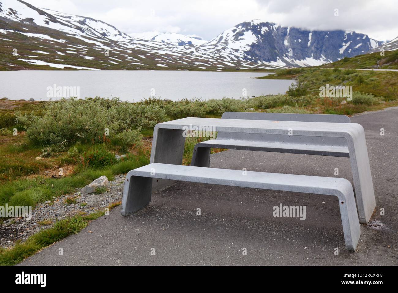 Inverno in estate - neve in Norvegia. Sunnmore Alpi tavolo da picnic in un luogo di riposo. Foto Stock