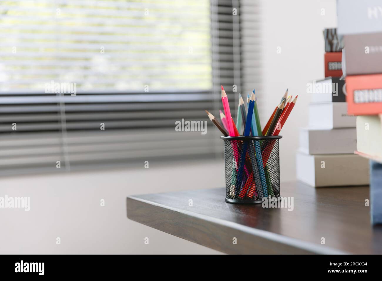Forniture scolastiche su un tavolo di legno in interni caldi, libri scolastici sul tavolo, concetto educativo. Foto Stock