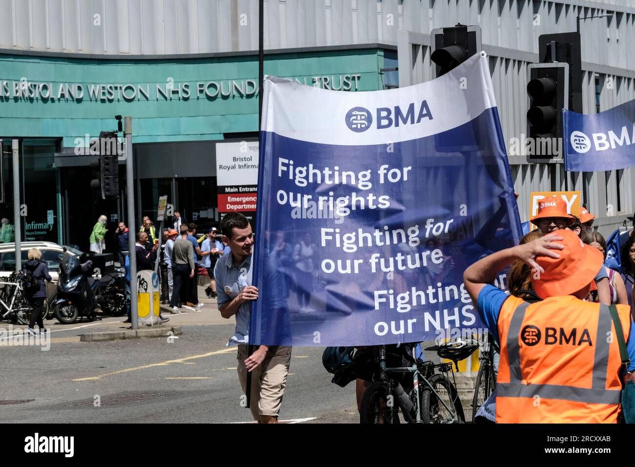 Bristol, Regno Unito. 17 luglio 2023. I giovani medici marciano dalla Royal Infirmary di Bristol per segnare la fine del quarto round del loro sciopero. L'azione industriale sostenuta dalla BMA e dall'HCSA promuove la richiesta di retribuzione del Dottore, che mira a ripristinare il reddito perso da anni di aumento delle retribuzioni al di sotto dell'inflazione. Anche se il governo ha offerto un aumento del 6,5%, i medici continuano a protestare perché l'ultima offerta non risponde alla loro necessità di ripristino delle retribuzioni. Crediti: JMF News/Alamy Live News Foto Stock