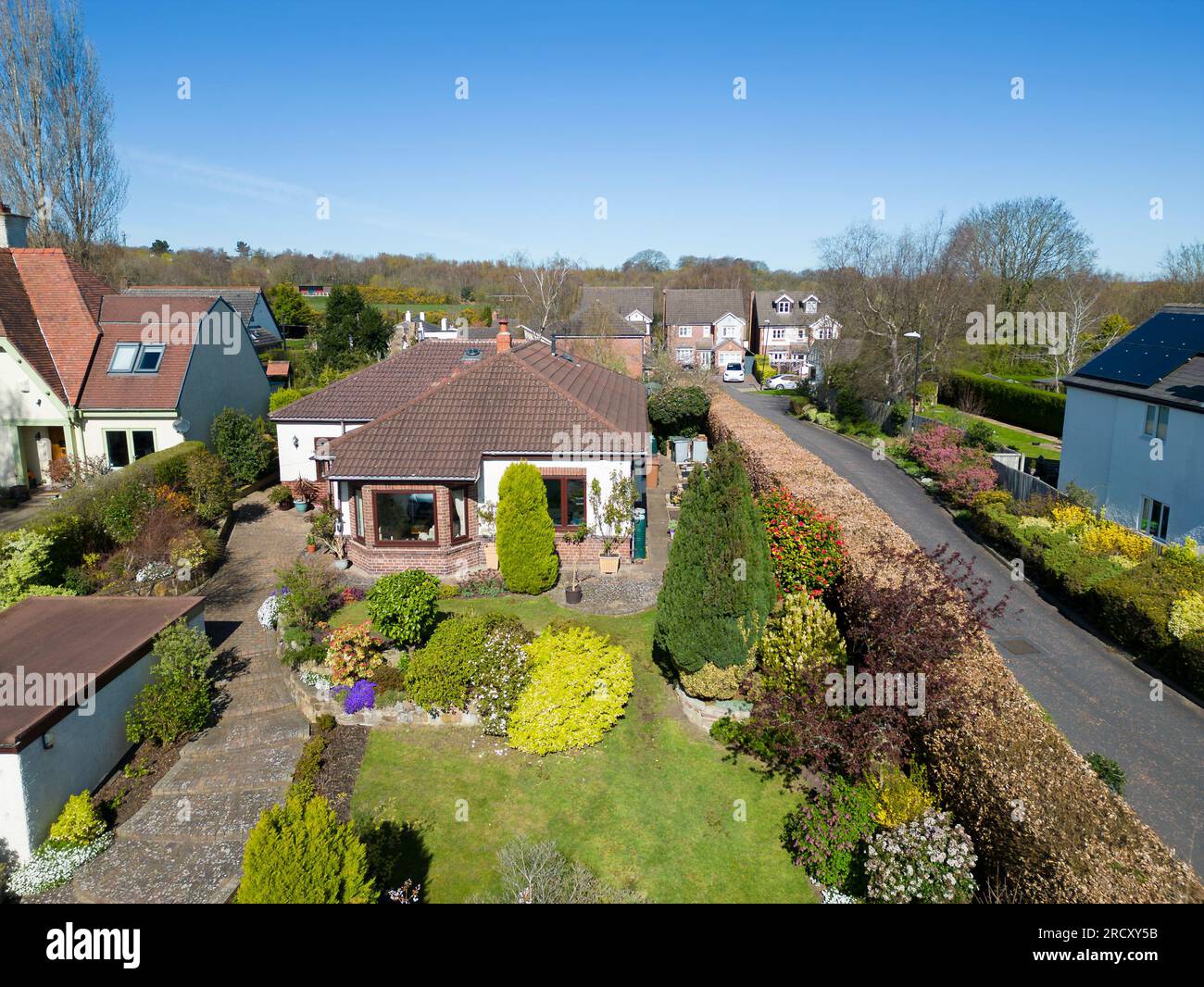 Vista aerea del bungalow inglese e del giardino frontale in una giornata di sole con cielo blu, Inghilterra Foto Stock