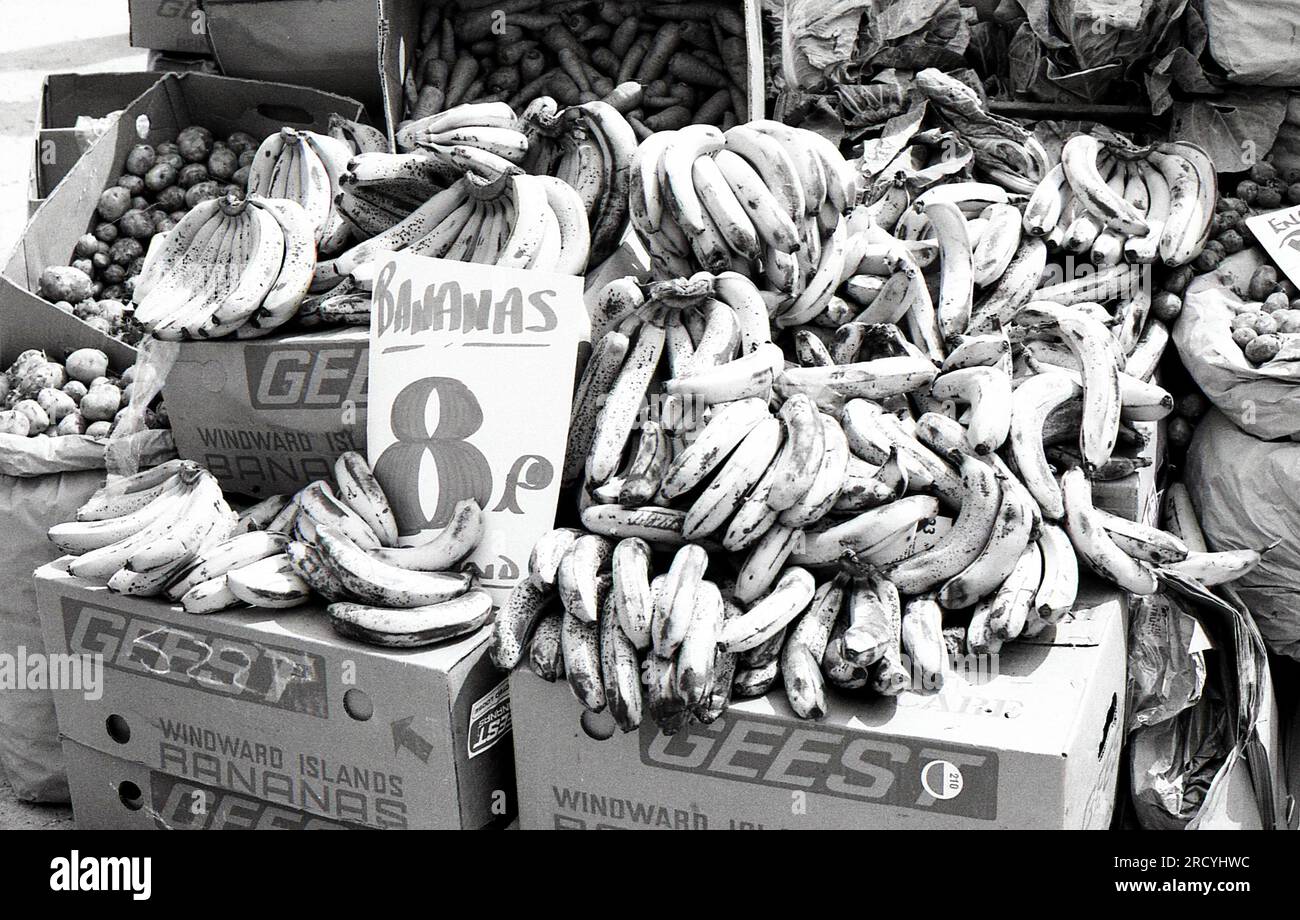 Hands of Geest Bananas in vendita su una bancarella di frutta e verdura al Bolney Market nel West Sussex, Inghilterra, il 27 giugno 1976. La Geest vendette la sua attività nel settore della banana nel 1995. Foto Stock