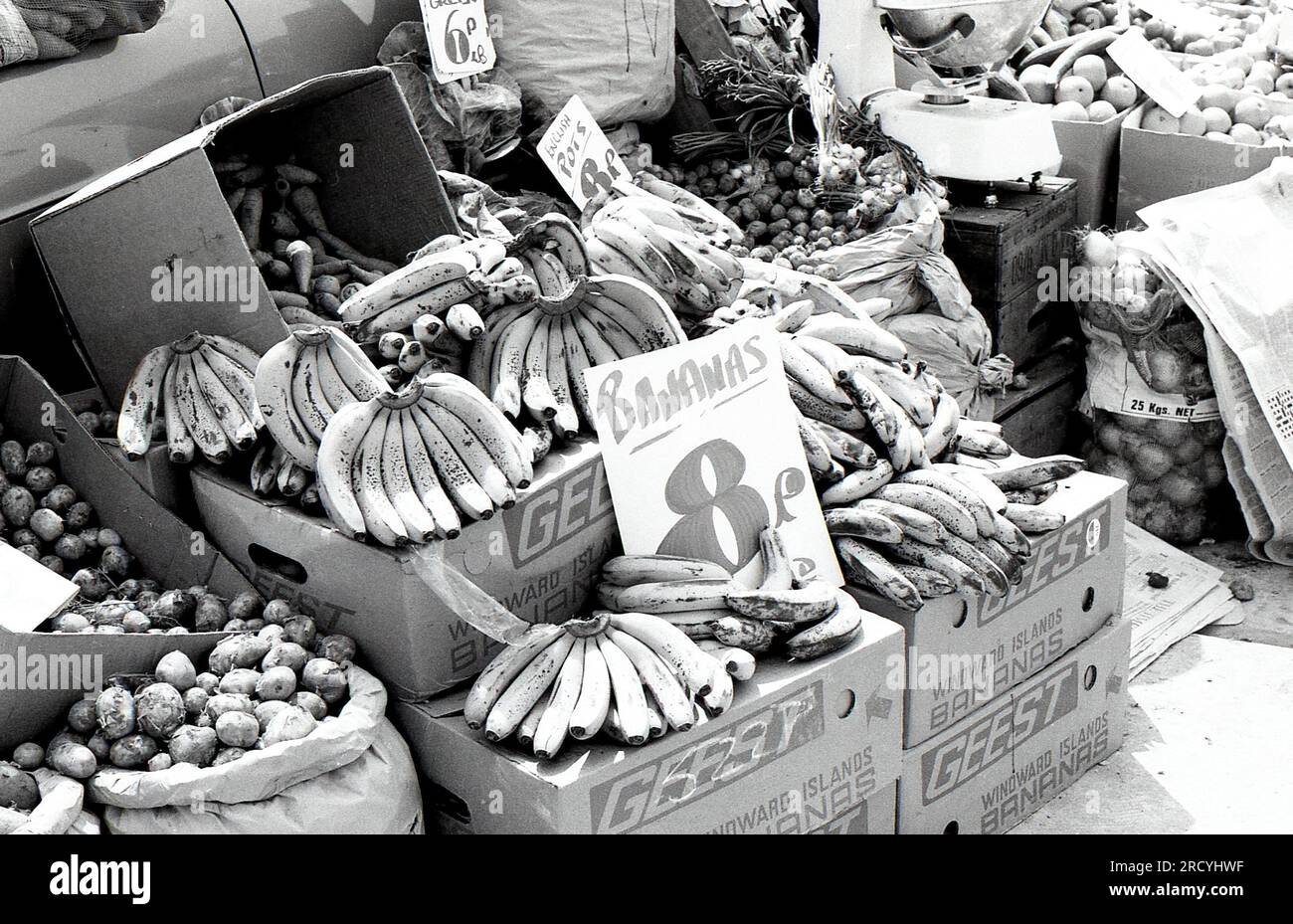 Hands of Geest Bananas in vendita su una bancarella di frutta e verdura al Bolney Market nel West Sussex, Inghilterra, il 27 giugno 1976. La Geest vendette la sua attività nel settore della banana nel 1995. Foto Stock