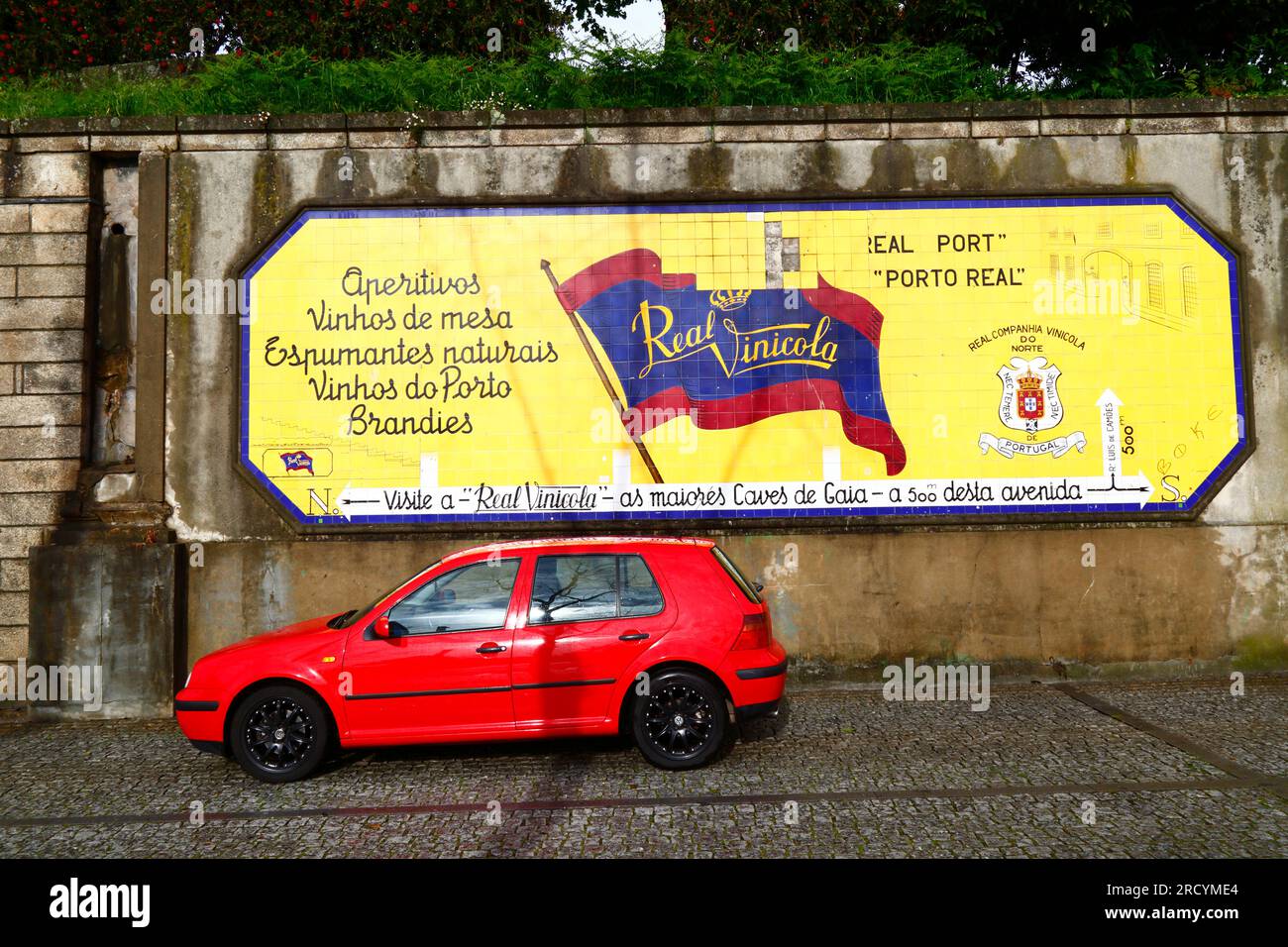 Auto rossa parcheggiata di fronte a un annuncio in piastrelle di ceramica per la società vinicola Real Companhia Vinícola do Norte, Vila Nova de Gaia, Portogallo Foto Stock