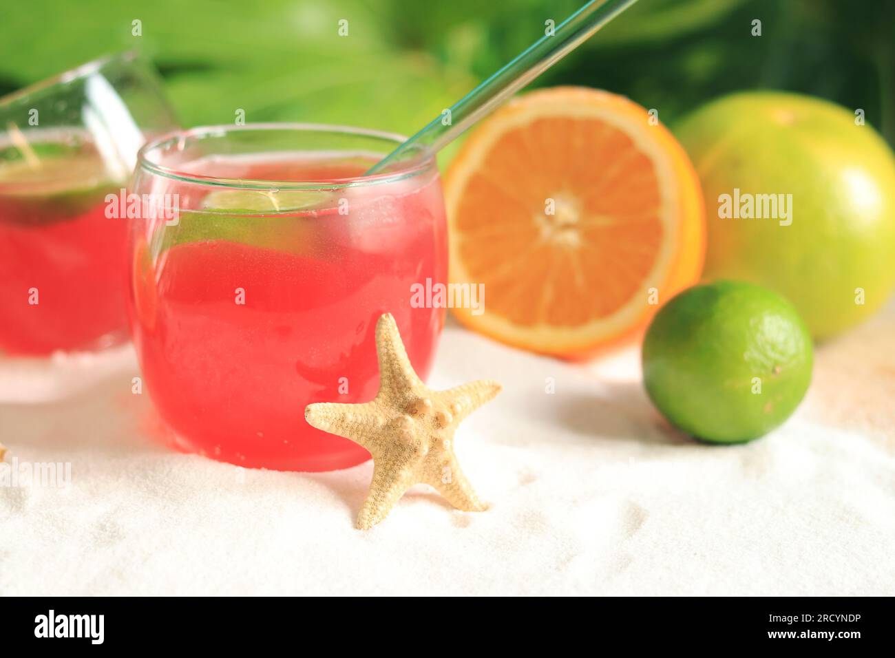 Cocktail alcolico di colore rosa vicino a frutti tropicali. Drink fresco sulla spiaggia. Messa a fuoco selettiva Foto Stock