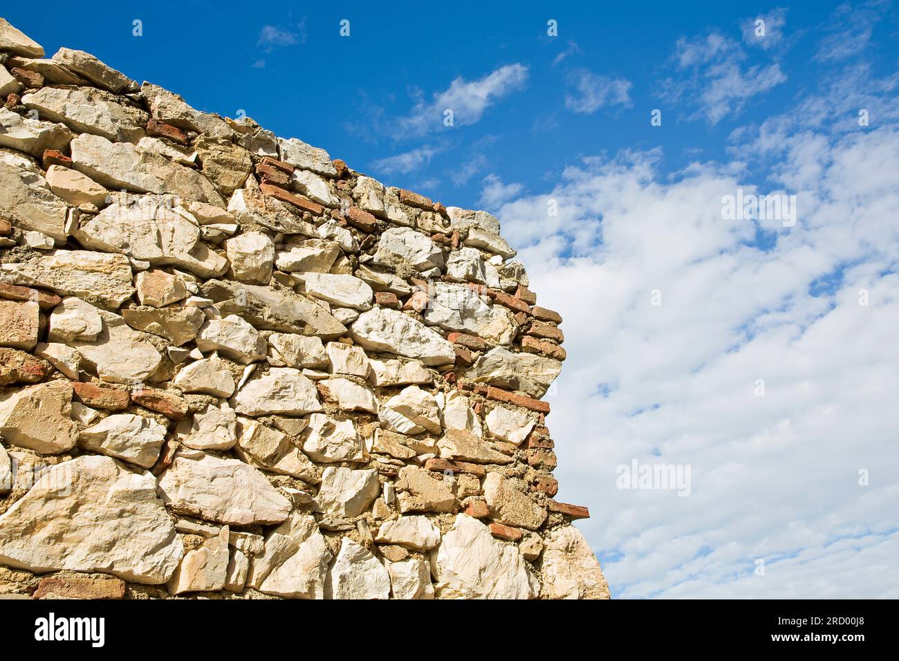 Muro di pietra con grandi blocchi di pietra sullo sfondo del cielo. Foto Stock