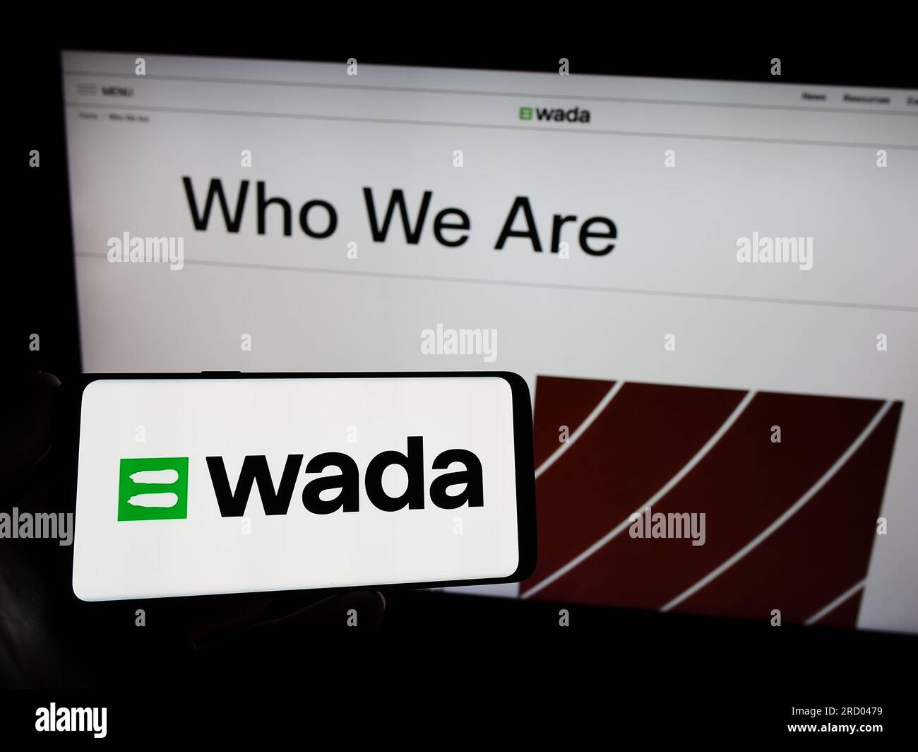 Persona che possiede uno smartphone con il logo dell'organizzazione World Anti-doping Agency (WADA) sullo schermo di fronte al sito web. Concentrarsi sul display del telefono. Foto Stock