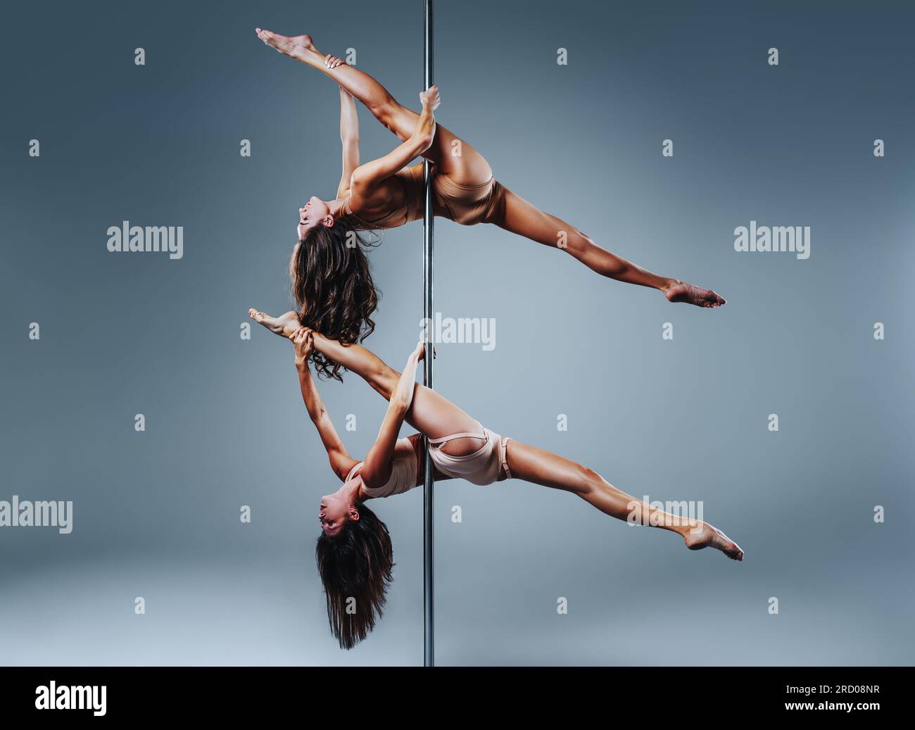 Due donne slim pole dance su sfondo bianco Foto Stock