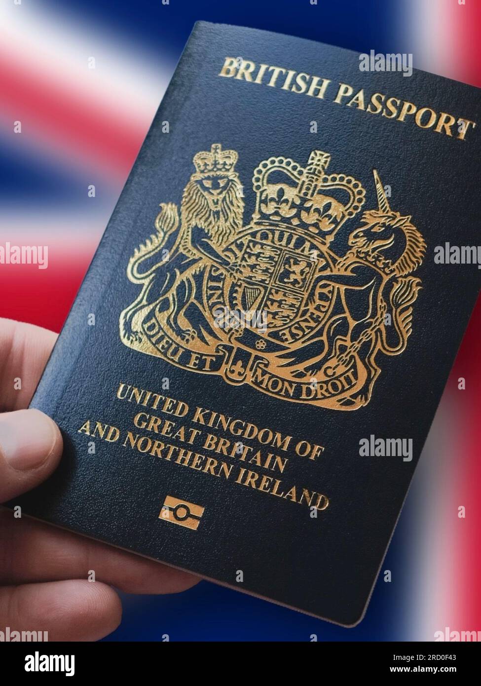 Mano che tiene un passaporto britannico di fronte all'Union Jack. Documento di viaggio per Untied Kingdom e Irlanda del Nord Foto Stock