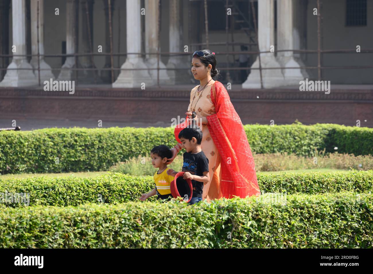 Agra, India -- Una foto di una donna indiana che cammina con i suoi figli in un giardino a Fort Agra, in India. Foto Stock