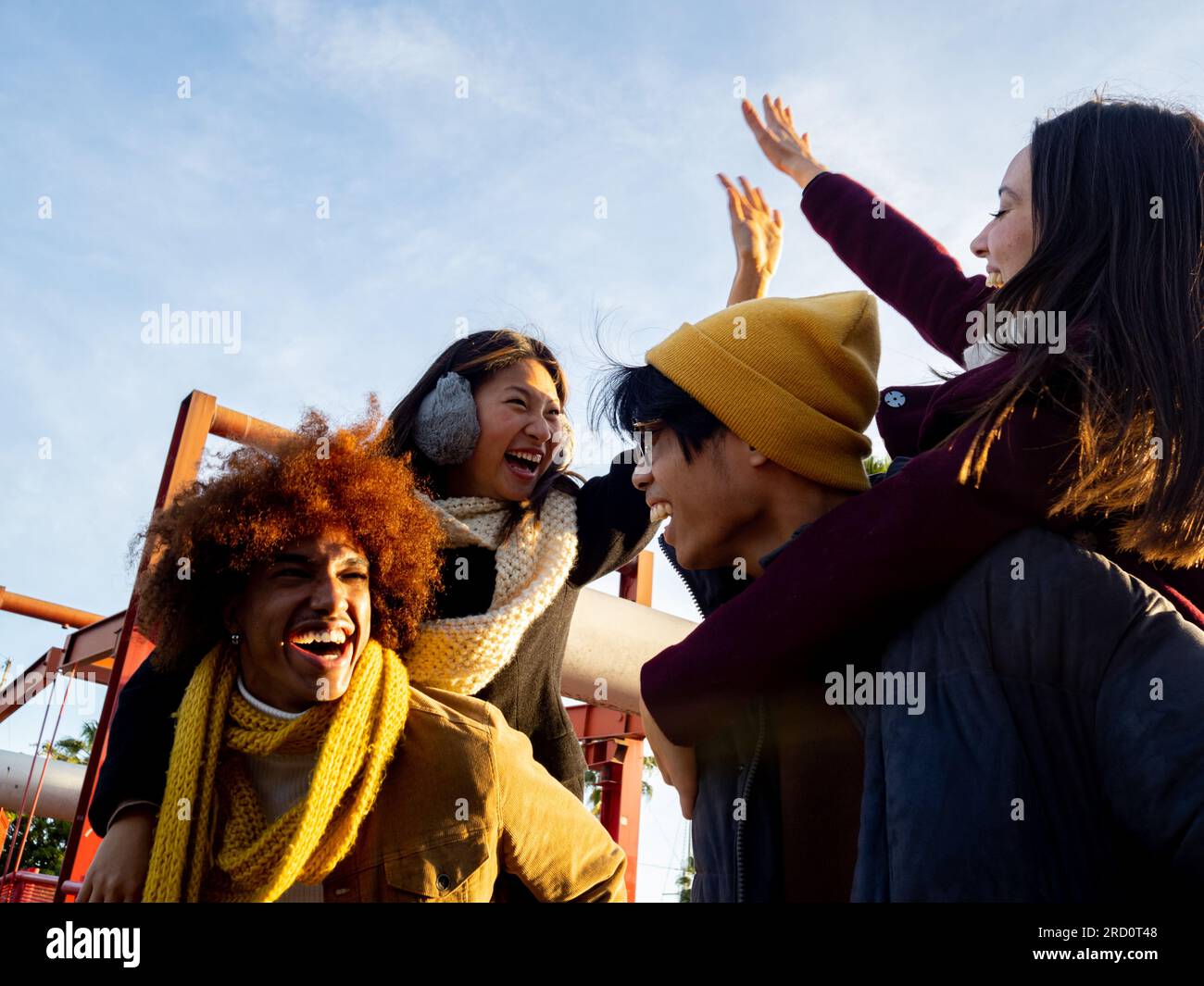 Gruppo di amici multietnici in abiti invernali che si divertono in una città. Concetto di comunità, amicizia, inverno Foto Stock