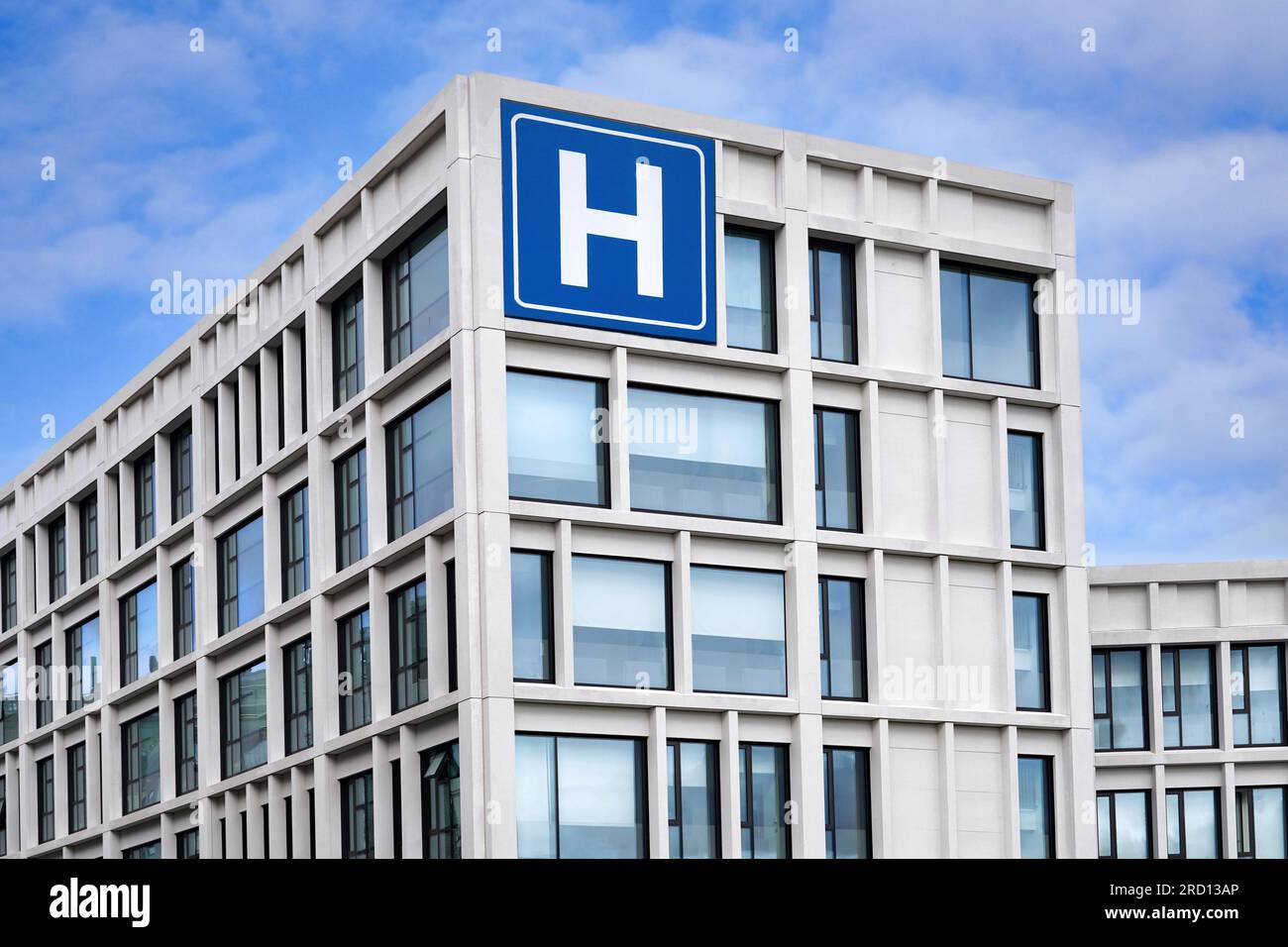 Moderno edificio in cemento con grande insegna blu H per l'ospedale Foto Stock