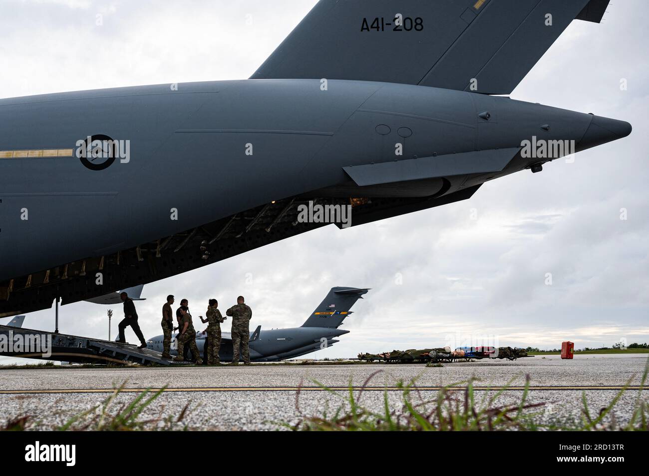 Prima frase: Royal Australian Air Force Airmen, assegnato al 3 Aeromedical Evacuation Squadron, e U.S. Gli avieri assegnati al 375th AES parlano di una missione di addestramento sulla rampa di un C-17 Globemaster III della RAAF sopra Andersen Air Force base Guam, 10 luglio 2023, per esercitazione Mobility Guardian 2023. MG23 è un'opportunità di formazione insieme ai nostri alleati e partner per dimostrare l'interoperabilità e rafforzare la nostra capacità collettiva di supportare un indo-Pacifico libero e aperto. (STATI UNITI Foto dell'aeronautica militare del sergente dello staff Devin M. Rumbaugh) Foto Stock