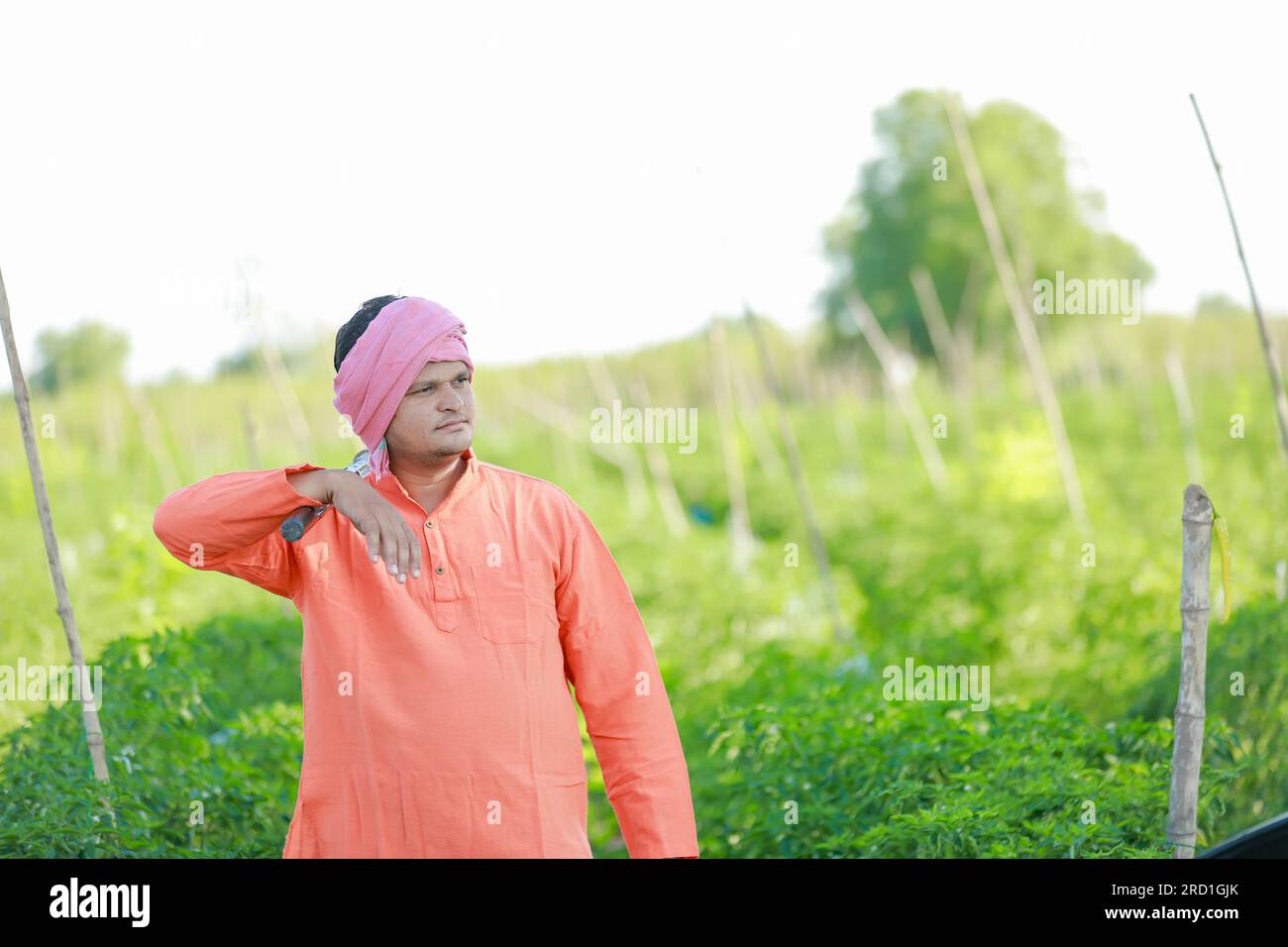 Felice agricoltore indiano, che tiene in mano gli strumenti agricoli Foto Stock