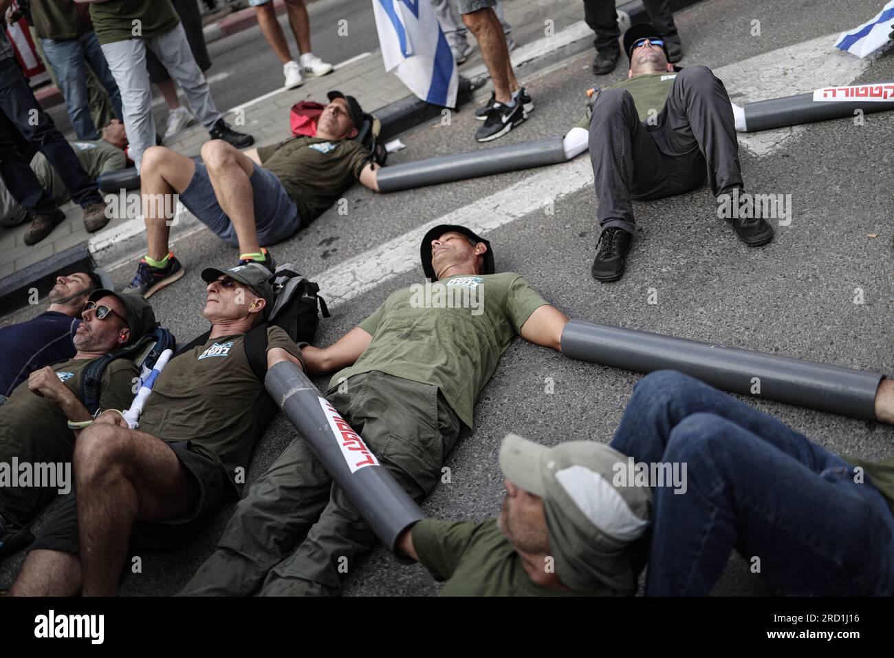 Tel Aviv, Israele. 18 luglio 2023. Gli attivisti israeliani del gruppo "Brothers in Arms" bloccano l'ingresso principale della base di Kiriya durante una protesta contro il governo israeliano. Crediti: Ilia Yefimovich/dpa/Alamy Live News Foto Stock