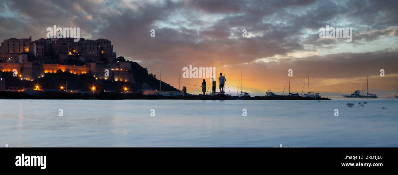 Spiaggia a Calvi Corsica francia, al tramonto sulla baia e con la silhouette della cittadella Foto Stock