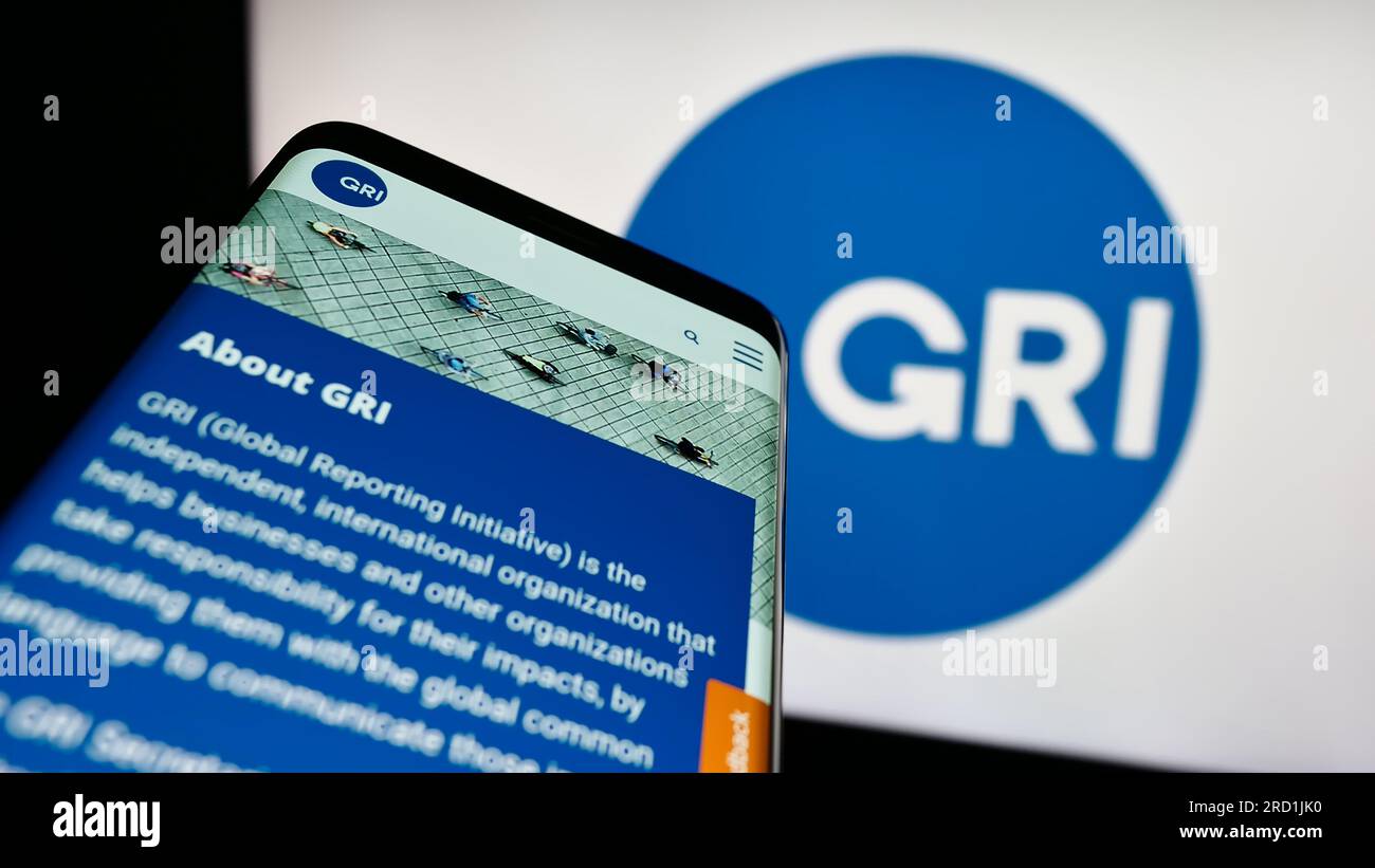 Telefono cellulare con sito Web della Global Reporting Initiative (GRI) sullo schermo davanti al logo. Mettere a fuoco in alto a sinistra sul display del telefono. Foto Stock