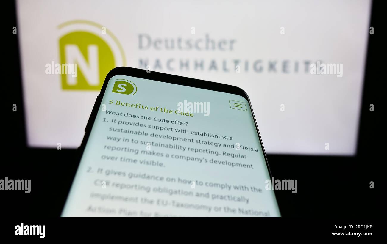 Smartphone con sito web di Deutscher Nachhaltigkeitskodex (DNK) sullo schermo davanti al logo. Mettere a fuoco in alto a sinistra sul display del telefono. Foto Stock