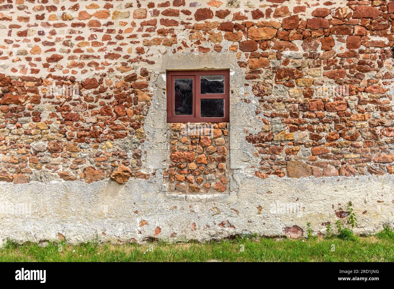 Porta bloccata dettaglio dei tradizionali materiali da costruzione in pietra rossa utilizzati per le case della Brenne - Rosnay, Brenne, Indre (36), Francia. Foto Stock