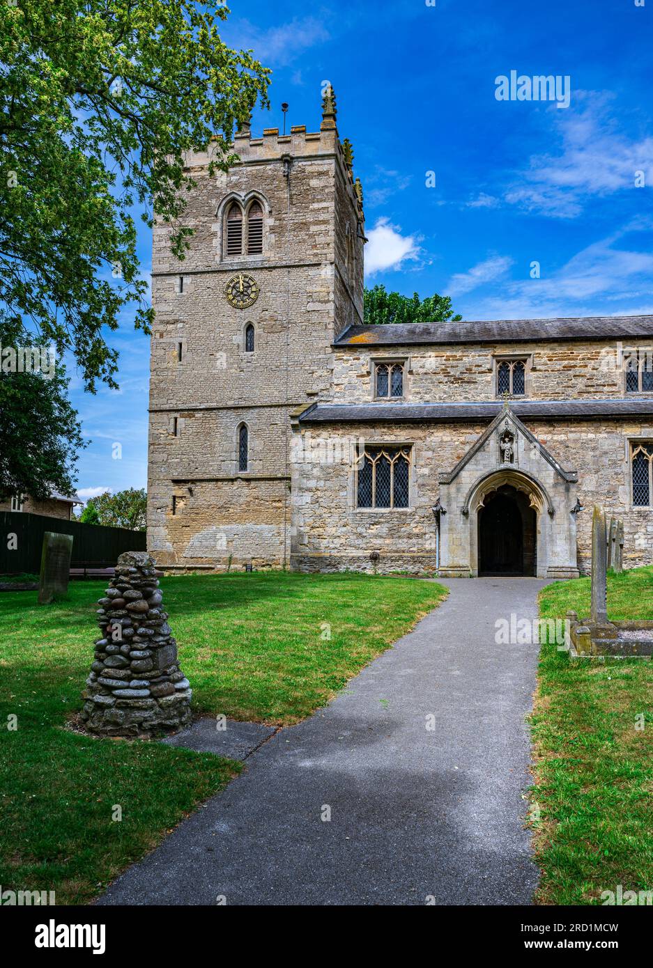 La chiesa del villaggio di St Chad, Dunholme, Lincolnshire, Regno Unito – la chiesa parrocchiale con la sua torre, che è principalmente medievale in costruzione, in un caldo pomeriggio estivo sotto un cielo blu Foto Stock