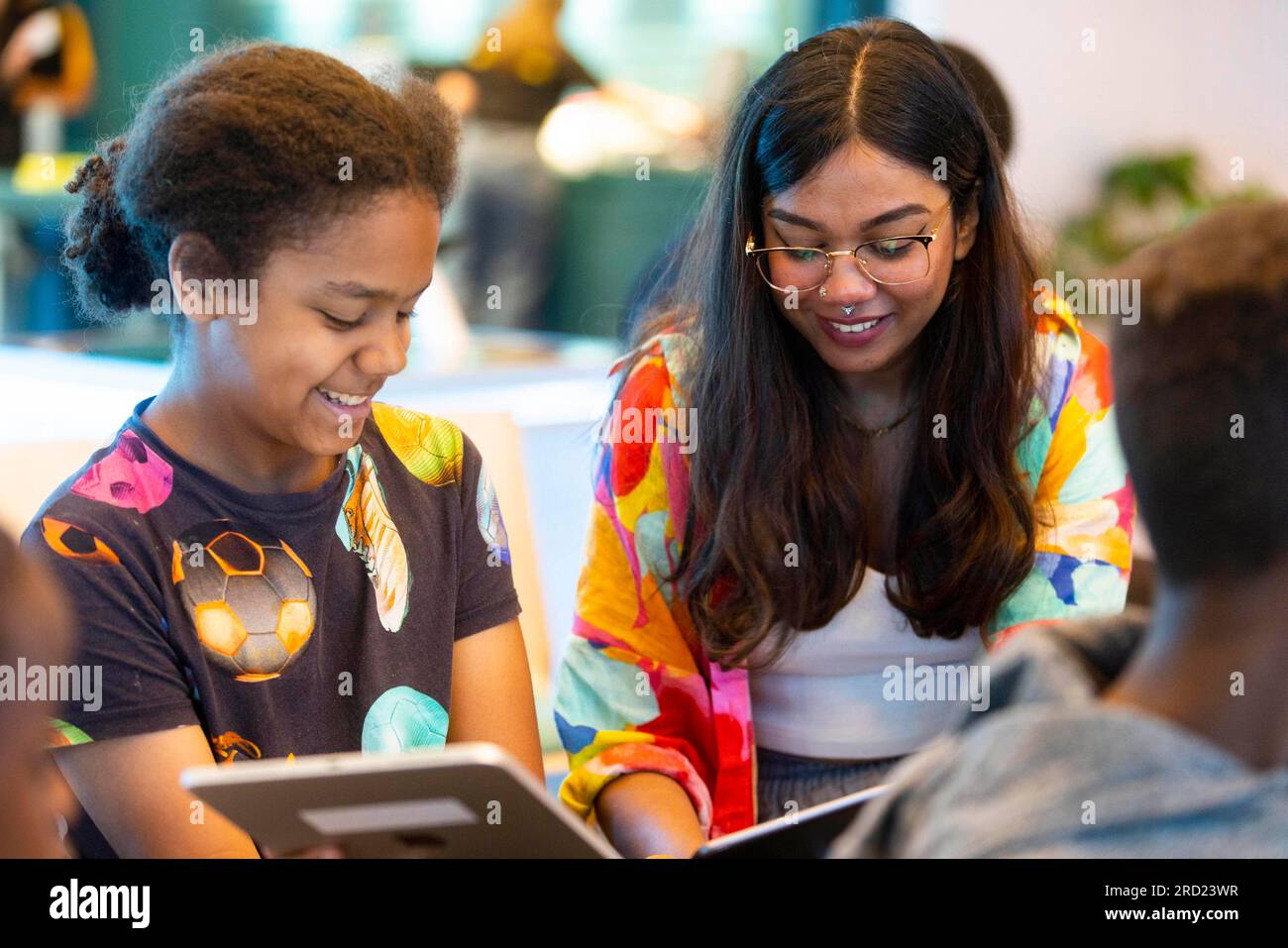 SOLO EDITORIALE Mohammed Rasoul di 11 anni, partecipa a un workshop di arte digitale guidato dall'illustratrice e romanziera professionista Fathima Hakkim (a destra) presso il nuovo negozio EE Studio di Westfield White City nell'ambito di una nuova partnership con il nostro Power Hub, Un gruppo comunitario creato per sostenere i residenti dopo l'incendio della Grenfell Tower e migliorare la loro qualità di vita. Data di emissione: Martedì 18 luglio 2023. Foto Stock