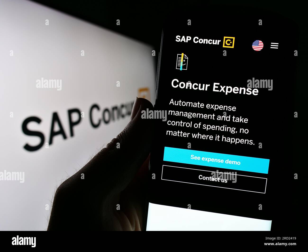 La persona che possiede il cellulare con il sito Web del software di gestione delle spese SAP concorda sullo schermo davanti al logo. Concentrarsi sul centro del display del telefono. Foto Stock