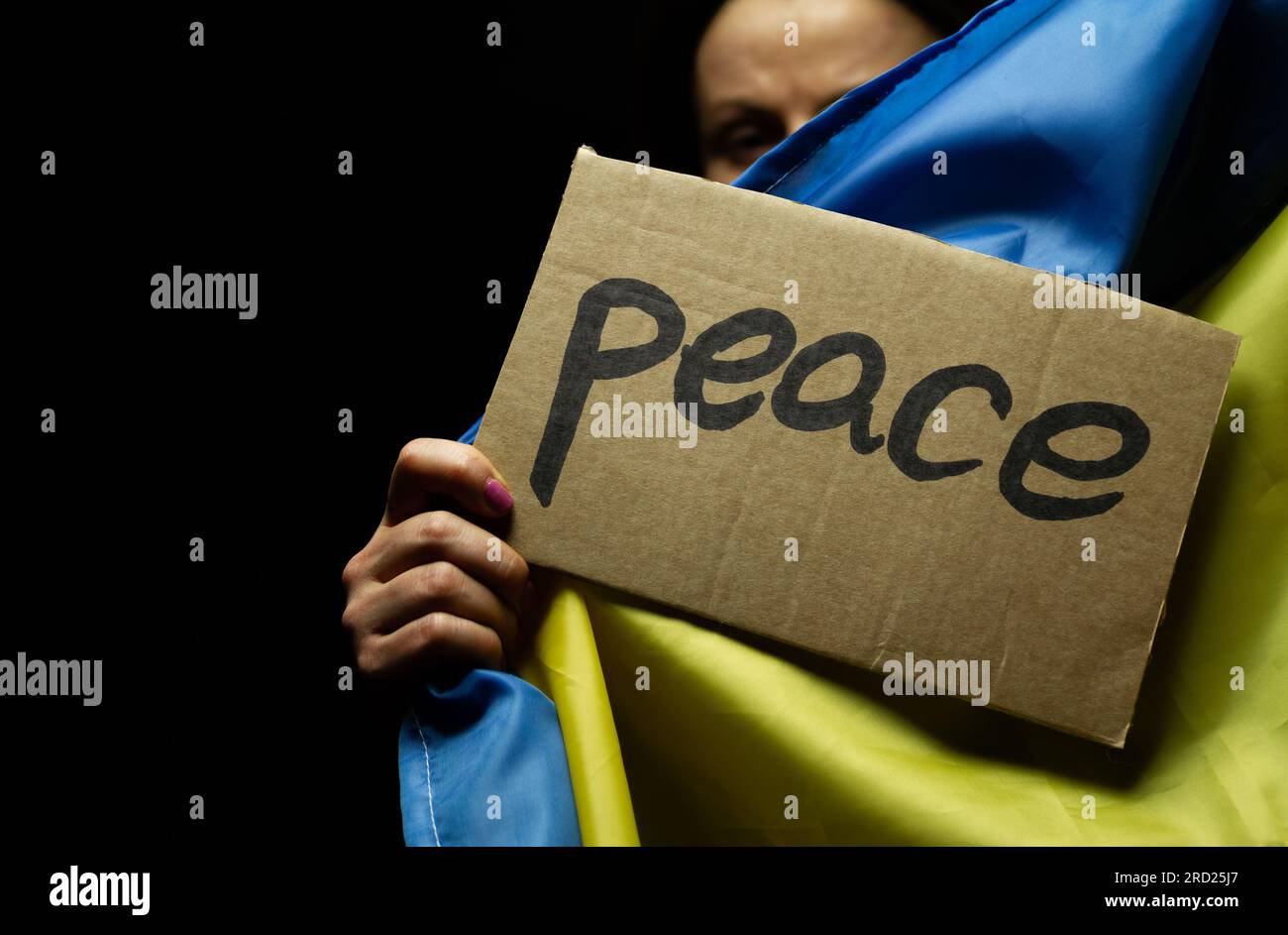 Donna con bandiera Ucraina e cartello di pace. Protesta contro l'invasione della Russia e la guerra contro l'Ucraina. Attacco russo, dimostrazione contro la guerra. Foto Stock