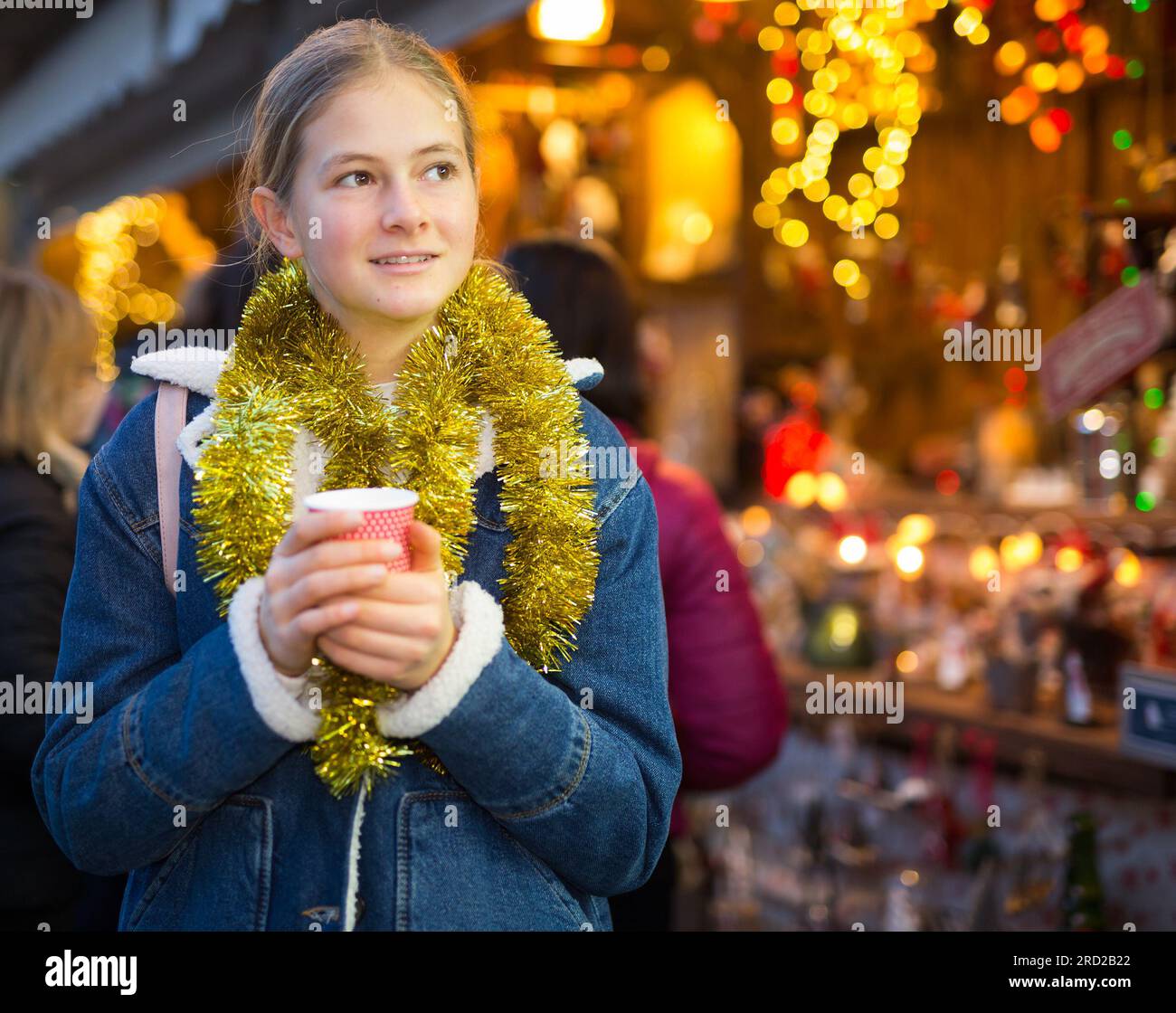 Ritratto di una ragazza adolescente con una tazza di caffè alla sera della fiera di natale Foto Stock