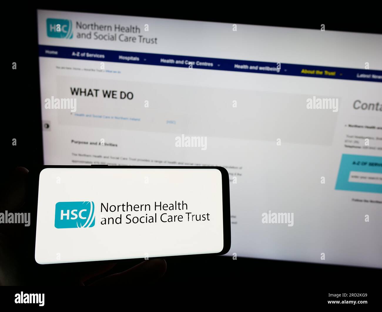Persona che possiede uno smartphone con il logo di Health and Social Care (HSC) in Irlanda del Nord sullo schermo di fronte al sito web. Concentrarsi sul display del telefono. Foto Stock
