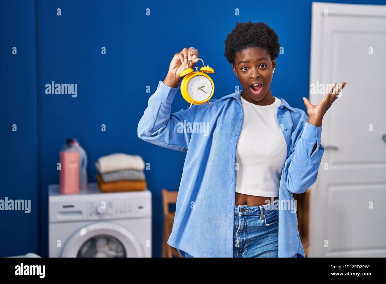 Donna afro-americana in attesa della lavanderia che celebra la vittoria con  un sorriso felice e l'espressione vincente con le mani alzate Foto stock -  Alamy