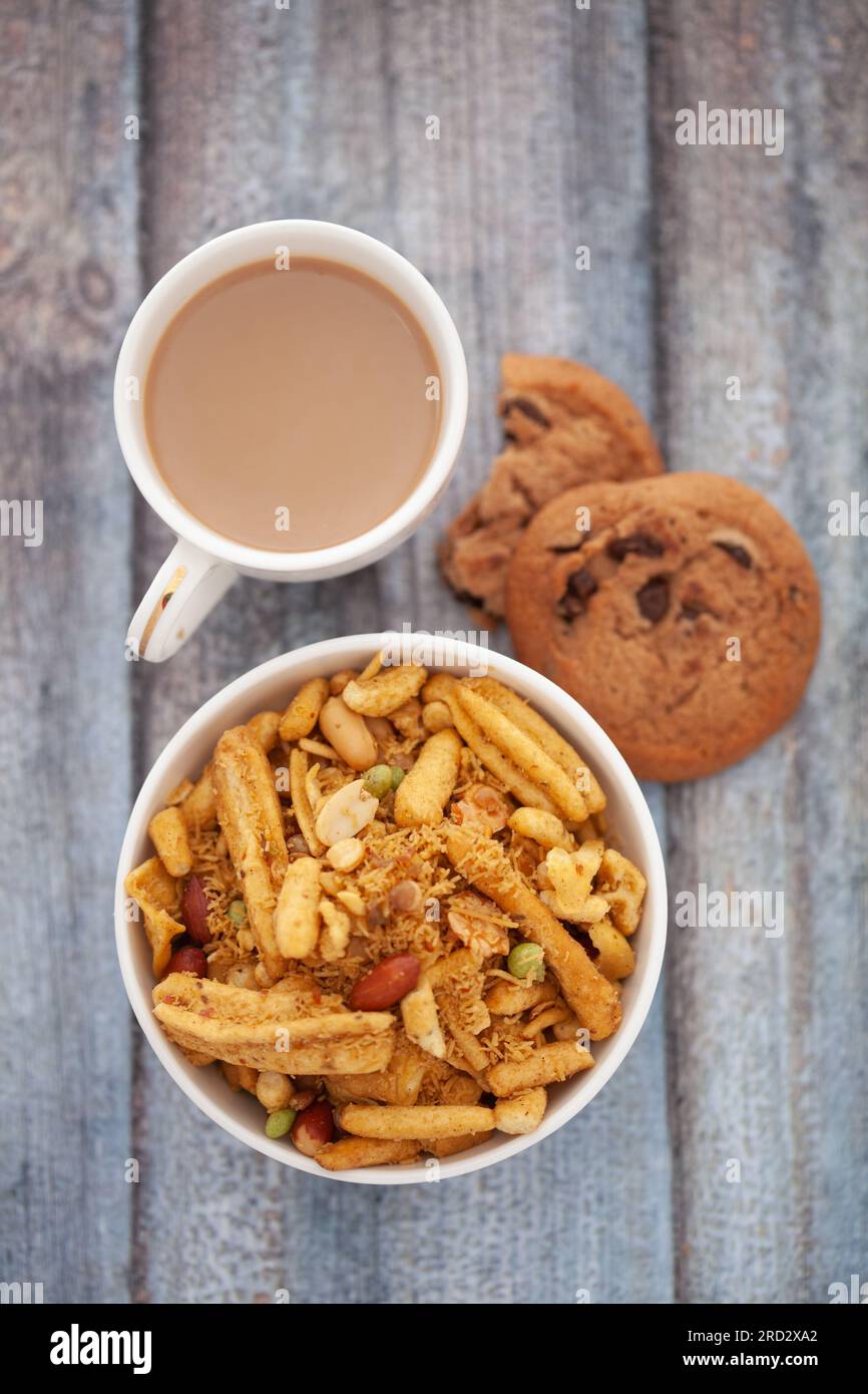 Primo piano di croccanti mix di spuntini indiani con tè caldo o caffè e biscotti fatti a mano Foto Stock