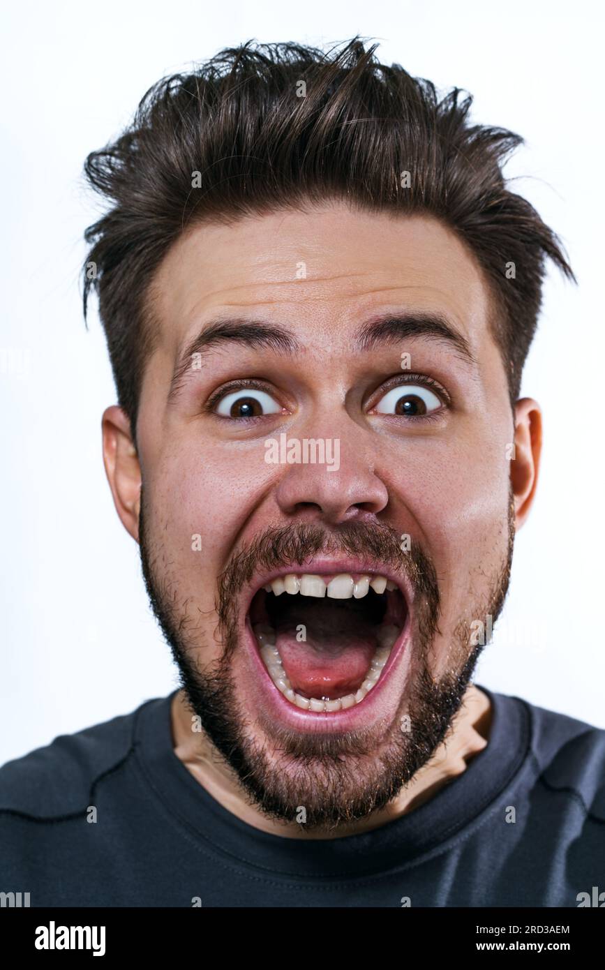 Giovane pazzo ritratto emozionale wow su sfondo bianco Foto Stock