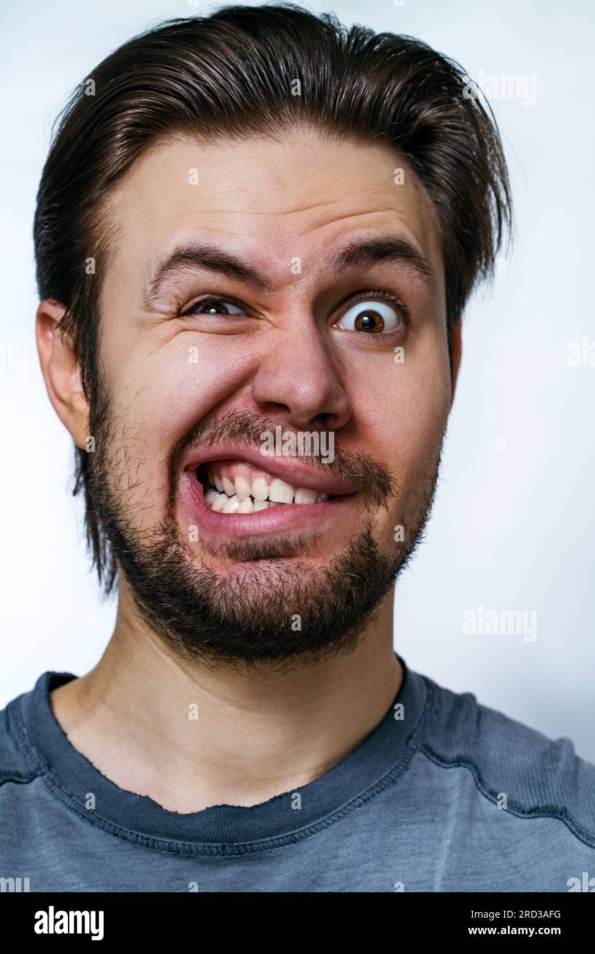 Giovane pazzo Danger uomo ritratto emotivo su sfondo bianco Foto Stock