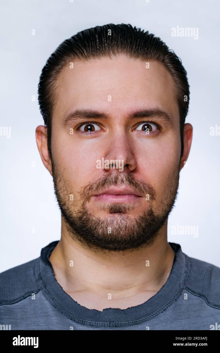 Giovane uomo serio con ritratto della barba su sfondo bianco Foto Stock
