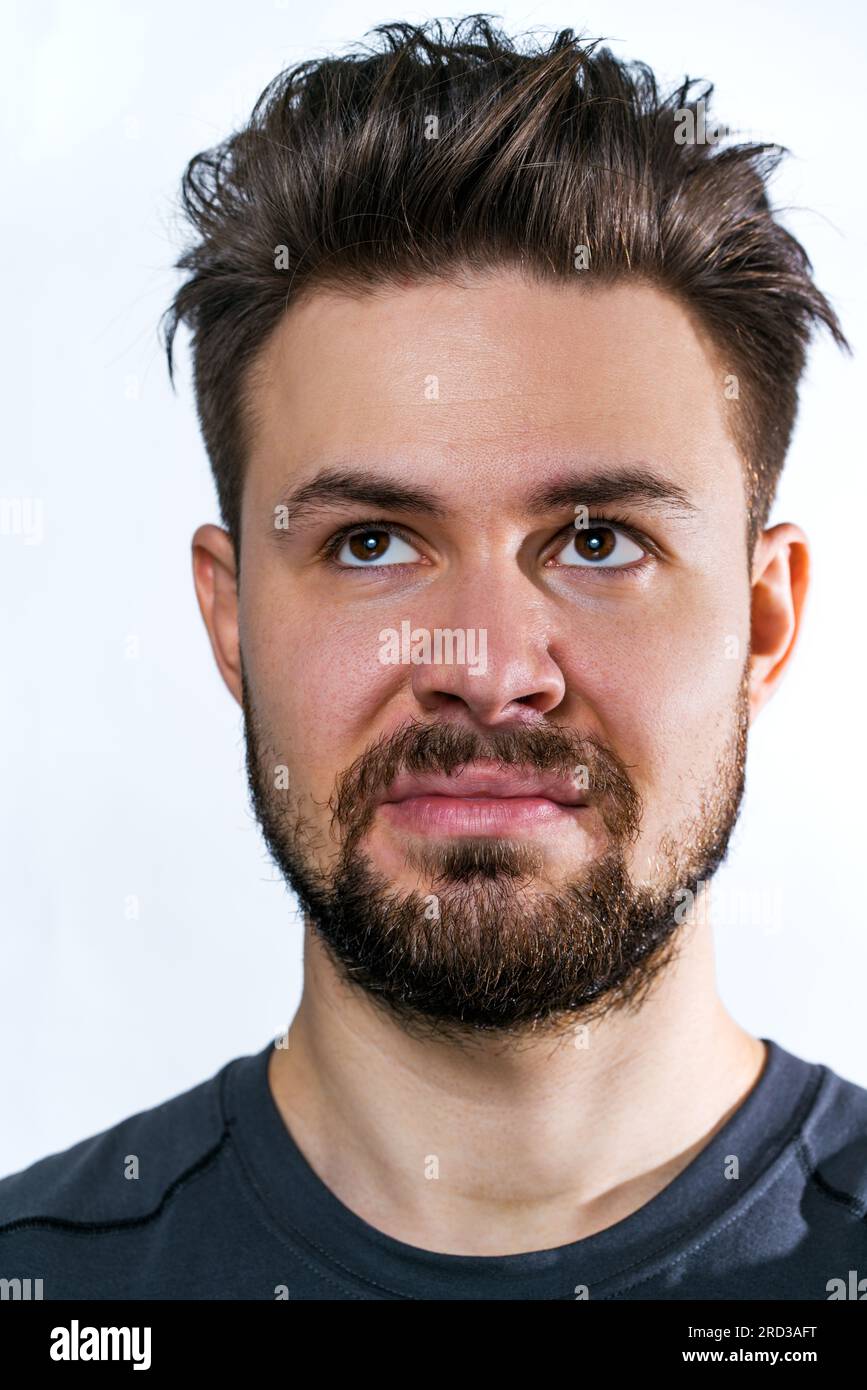 Giovane uomo insoddisfatto con un ritratto della barba su sfondo bianco Foto Stock