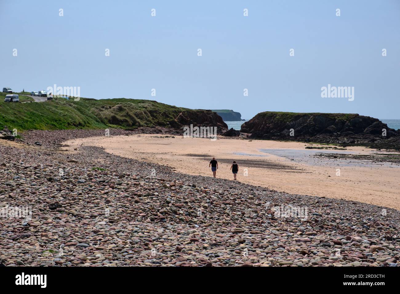 Una passeggiata di coppia lungo la spiaggia di Freshwater West nel Pembrokeshire Foto Stock