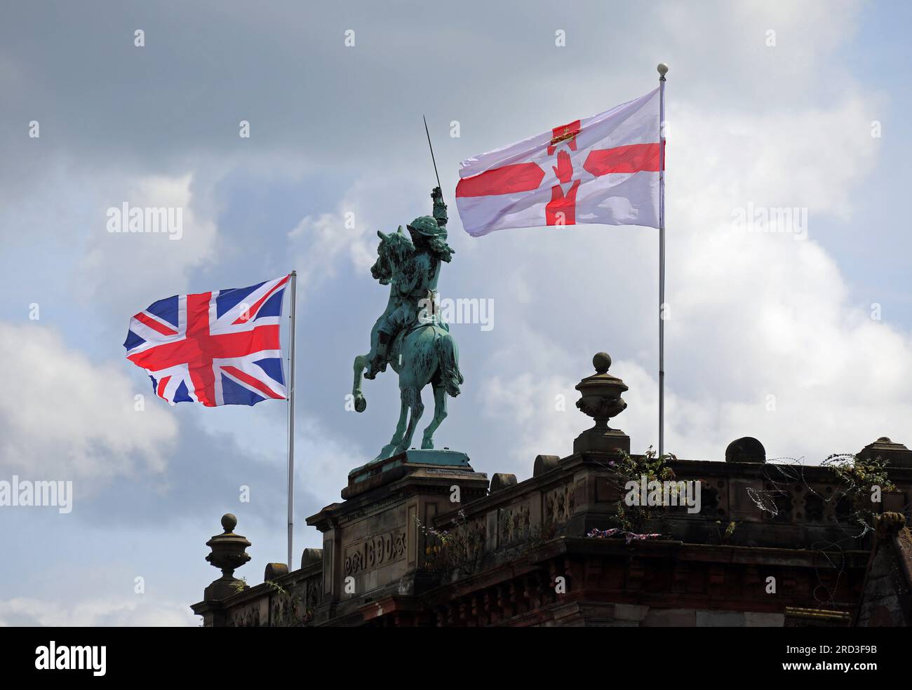 Bandiere che volano accanto alla statua equestre di re Guglielmo III nell'edificio Orange Hall a Belfast Foto Stock