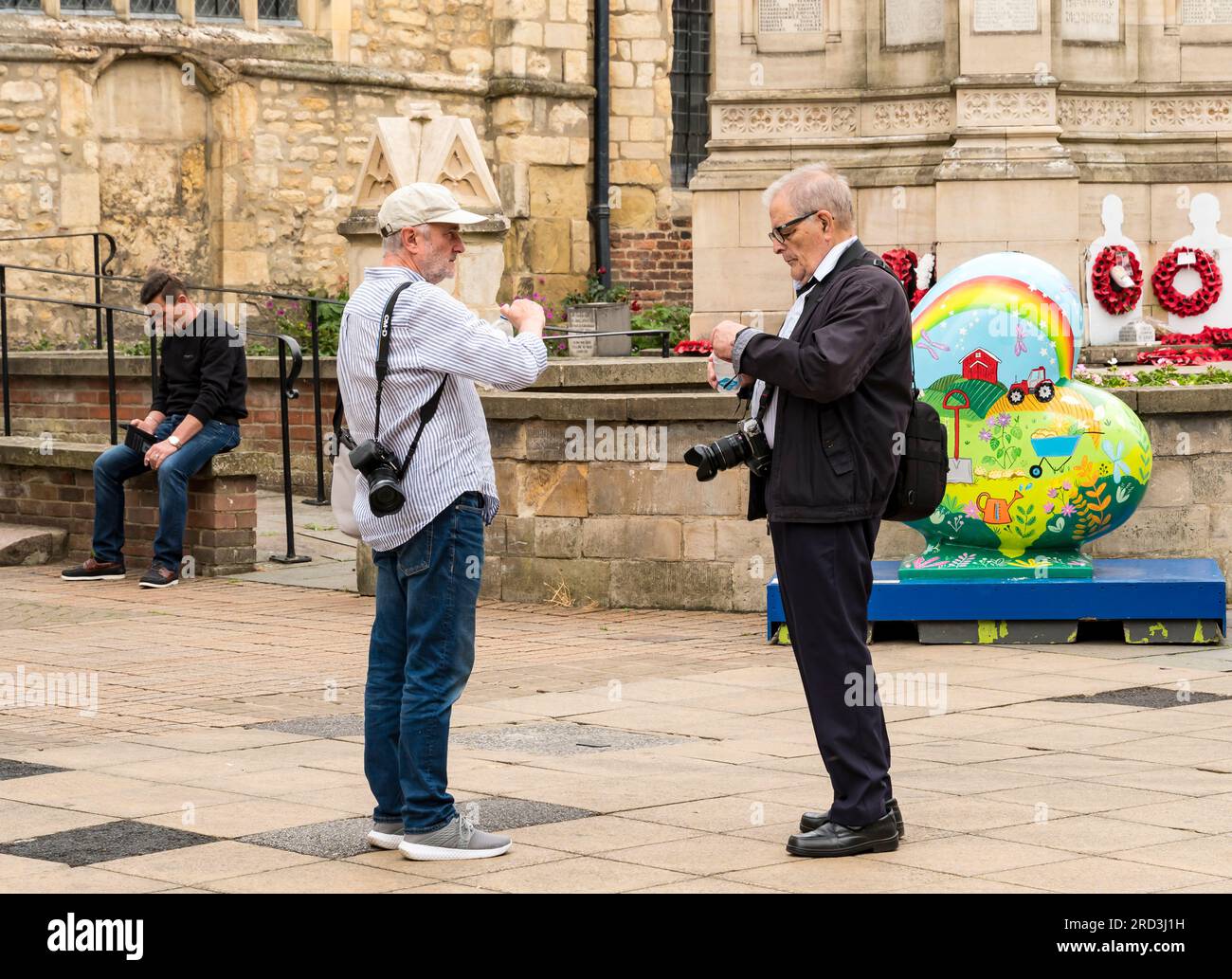 Due fotografi si sono fermati per una bevanda rinfrescante, High Street, Lincoln City, Lincolnshire, Inghilterra, REGNO UNITO Foto Stock