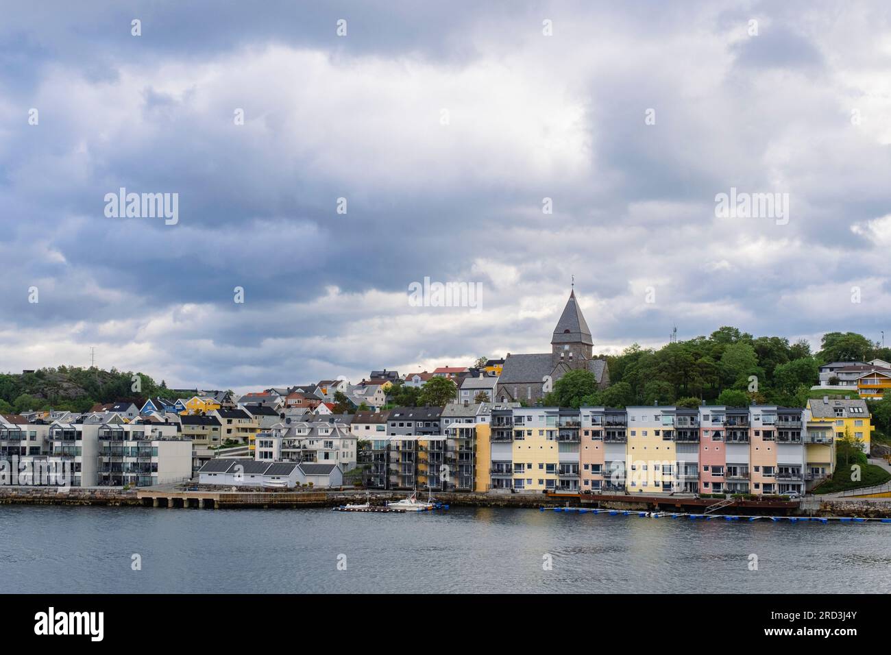 Vista sul porto dei moderni edifici sul lungomare e Nordlandet kirke o North Country Church sull'isola di Nordlandet. Kristiansund, Norvegia Foto Stock