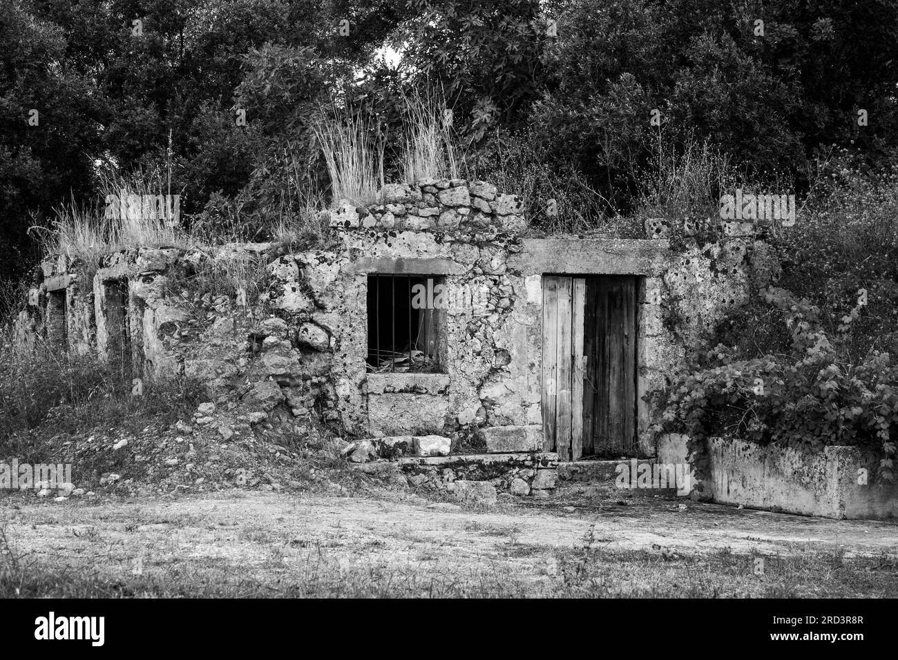 I resti rotti di una piccola dimora in pietra sono molto sovrapposti. Possibili danni da terremoto. Immagine monocromatica. Foto Stock