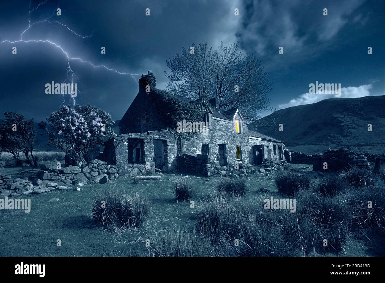 Abbandonati, forse, l'edificio di una fattoria infestata durante una tempesta con una luce all'interno. Foto Stock