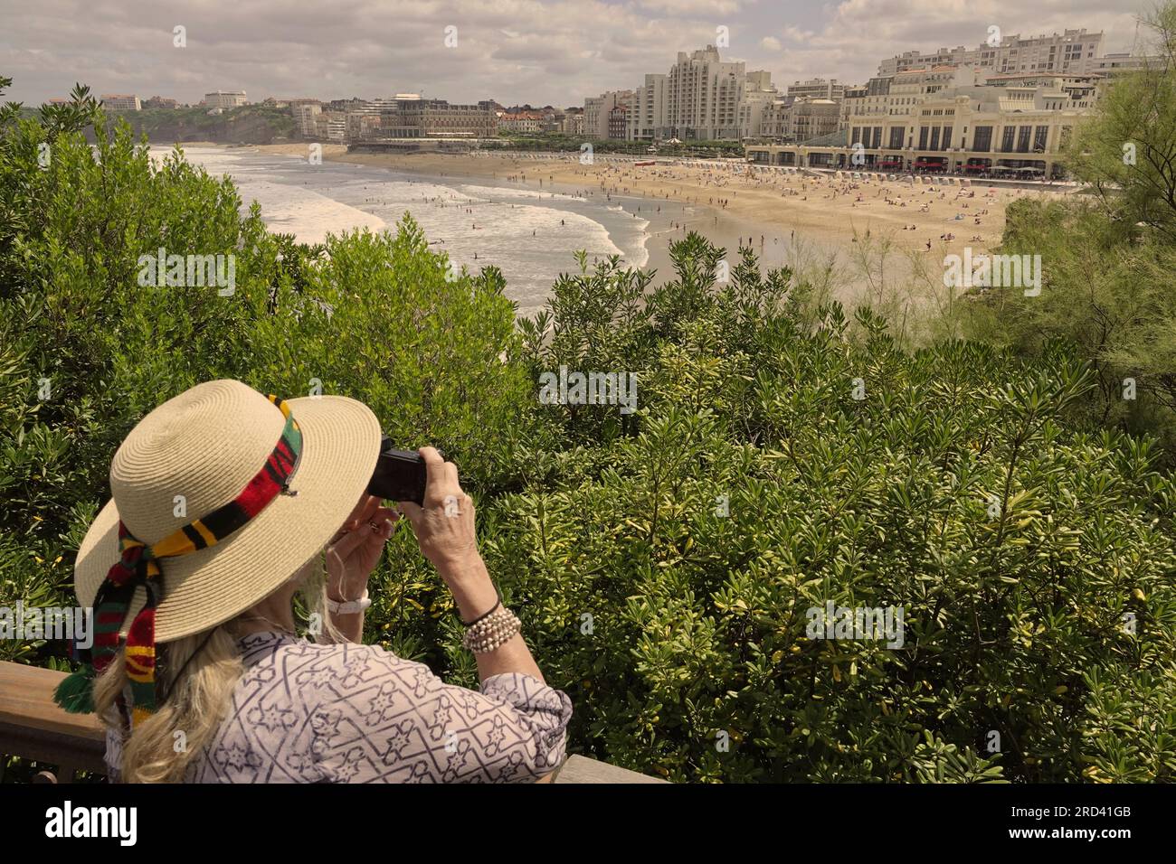 Biarritz, Francia, luglio, 2023 le donne si prendono una vacanza sulla spiaggia di Ó la grande PlageÓ, Biarritz - vista sul faro di le Phare e l'Hotel de Pal Foto Stock