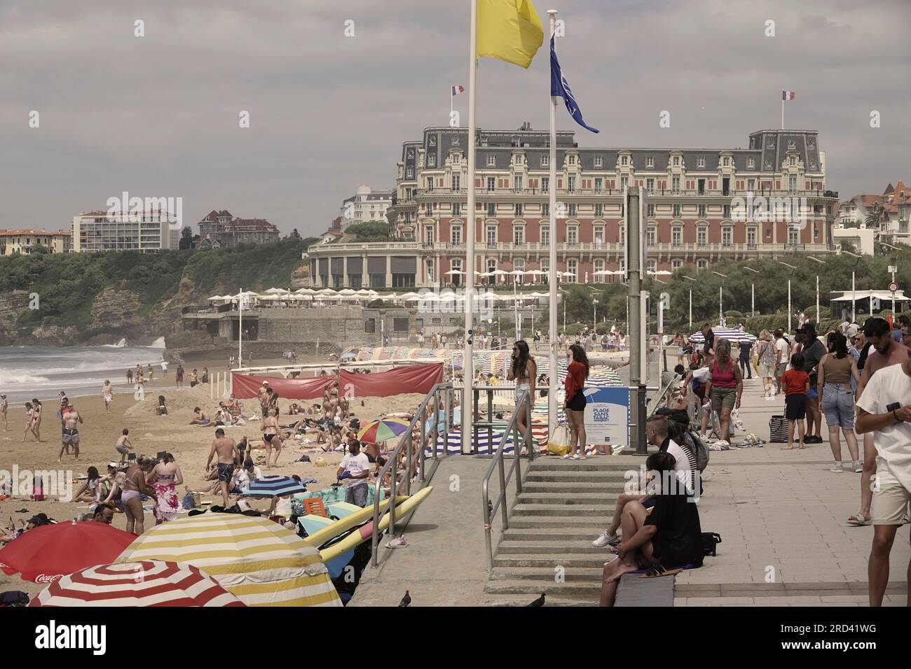 Biarritz, Francia, luglio 2023 Ó la grande PlageÓ Beach, Biarritz - con le colorate tende da spiaggia e vista sul famoso Hotel de Palais Foto Stock