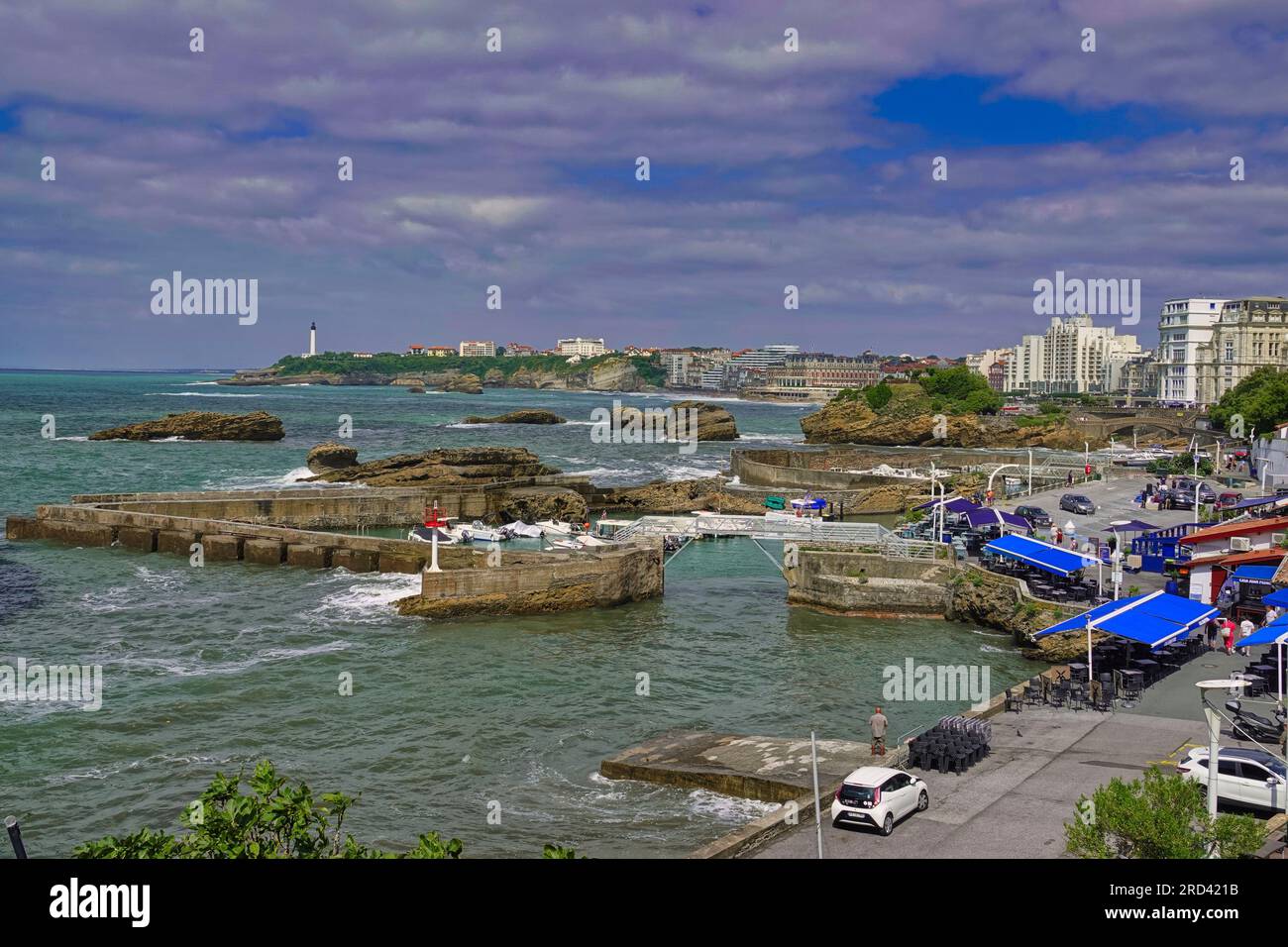 Biarritz, Francia, luglio, 2023 pittoreschi e colorati ristoranti sul pittoresco porto di Biarritz - vista sull'Hotel de Palais e le Phare lightho Foto Stock