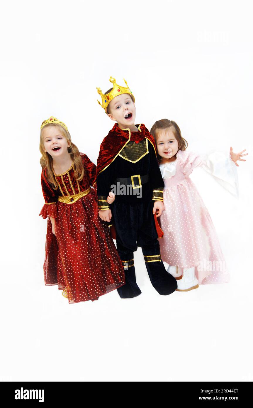 Re, regina e principessa ridono e parlano mentre si mettono in posa nei loro costumi di Halloween. I bambini indossano corone, abiti e mantello reale. Foto Stock