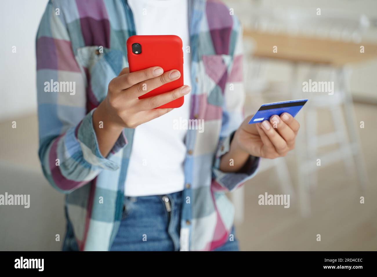 Shopping online sicuro: Mani in mano con carta di credito, smartphone. Pagamenti sicuri in ambienti chiusi. Foto Stock