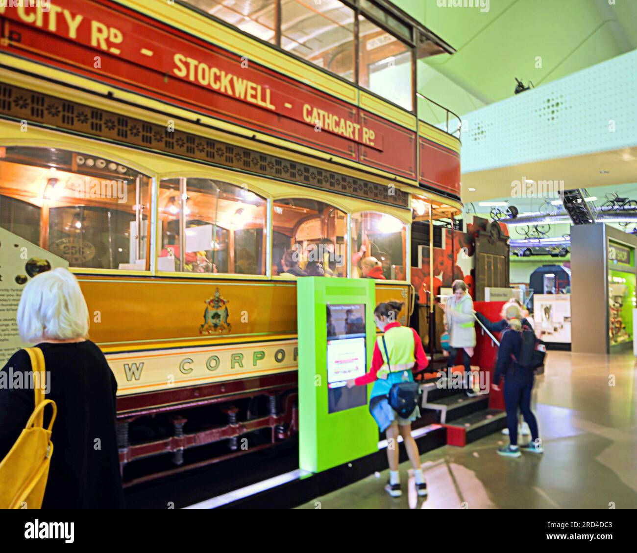 I turisti in tram cittadini e i gruppi di scolari in vacanza dalla scuola affollata Zaha Hadid museo dei trasporti lungo il fiume Foto Stock