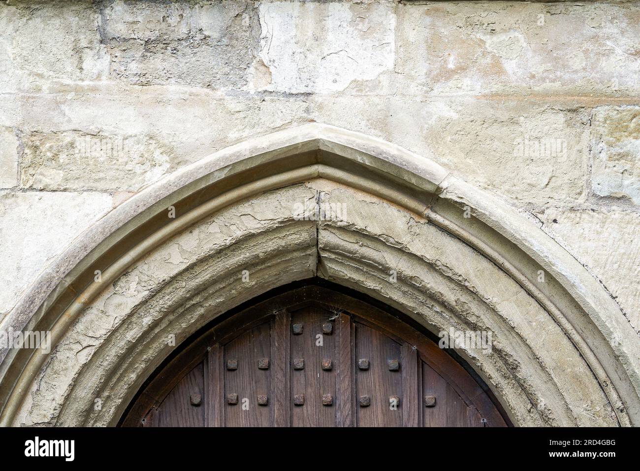 Parete in pietra e porta con borchie in ferro Foto Stock