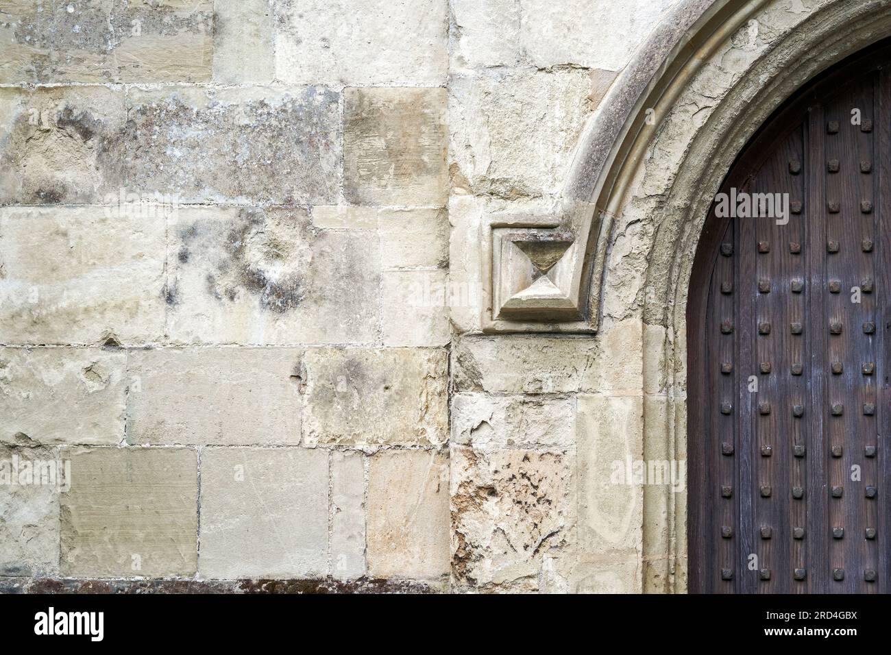 Parete in pietra e porta con borchie in ferro Foto Stock